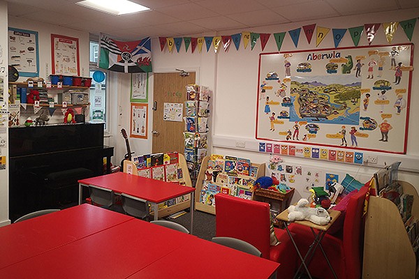 A colorful classroom with red tables and chairs