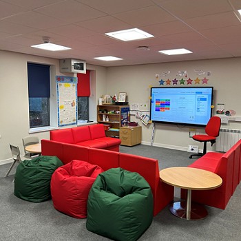 red chairs in a circle looking at a large screen