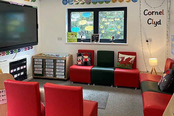 Ysgol Tryfan's school room with red chairs and a large screen on the wall