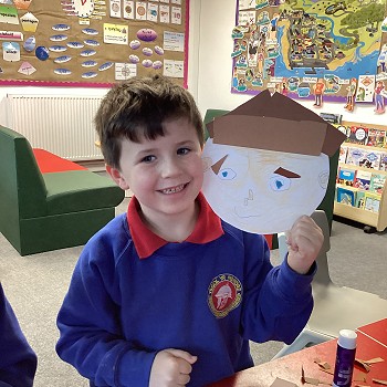 student doing a face made out of paper plates