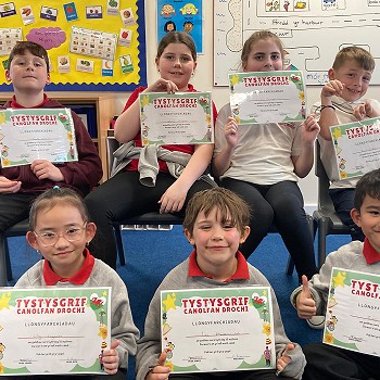 a collection of images of Ysgol cymerau pupils holding their certificates